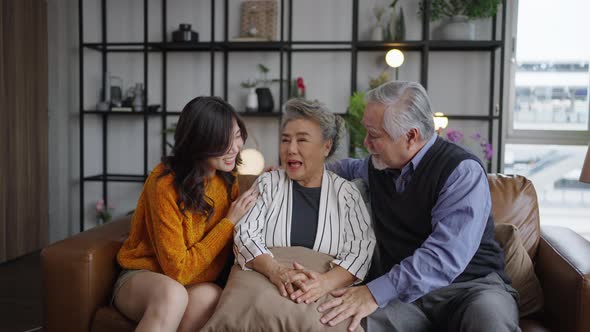 Portrait Asian family cuddling in sofa living room at home.