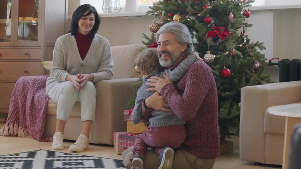 Happy Grandparents Giving Christmas Present to Grandchild