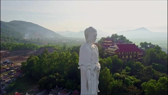 Drone Passes Large White Buddha Statue and Moves To Temple