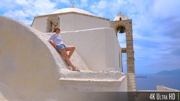 4K Pretty young woman enjoying view from on top of Greek Church rooftop