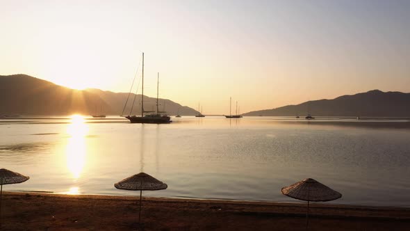 View to Sea Bay with Sailboats From Sandy Beach During Sunrise