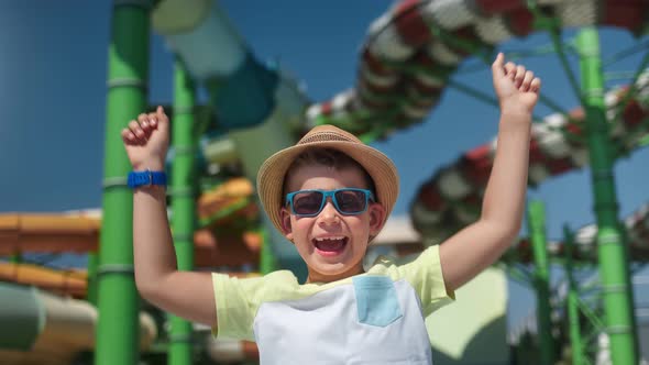 Charming Happy Cute Child Laughing Jumping Having Fun at Slide Aquapark Background