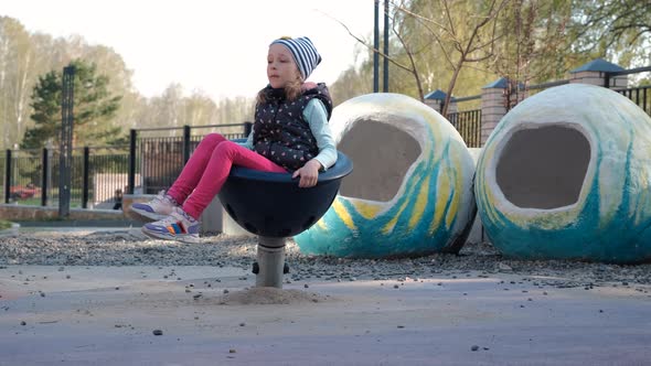 Little Girl is Bored at a Playground Area