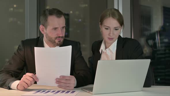 Executive Business People Discussing on Laptop Screen at Night