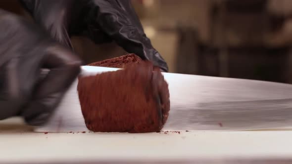 The Cook Cuts Freshly Baked Bread In Black Gloves