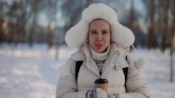 Portrait of a Cute Homosexual Man Walking Outside in Winter with Hot Coffee in His Hands