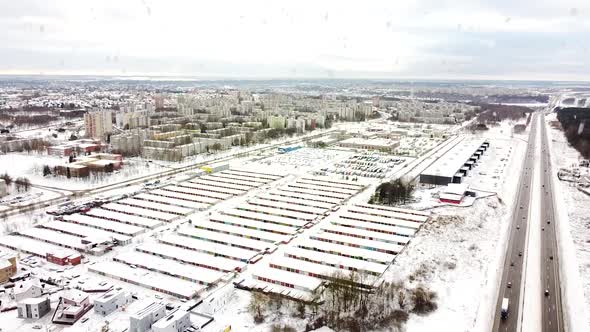 Kalnieciai district and many garage boxes during heavy snowfall in winter season, aerial view