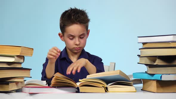 Tired Boy Sitting at a Table for a Book Falls Asleep and Wakes Up. Blue Background