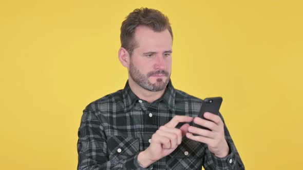Portrait of Middle Aged Man Reacting to Loss on Smartphone