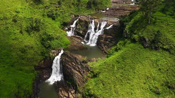 Aerial View of Waterfall Among Green Hills