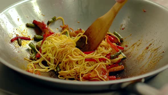 CU, Slow Motion: Cook Prepares Noodles Pasta in Frying Pan, in Oil, with Fresh Vegetables