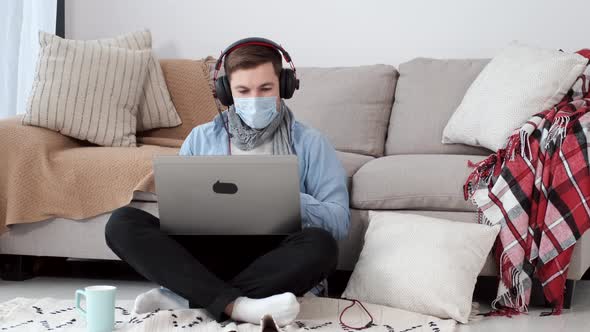 Young Businessman Working at Home with Face Mask