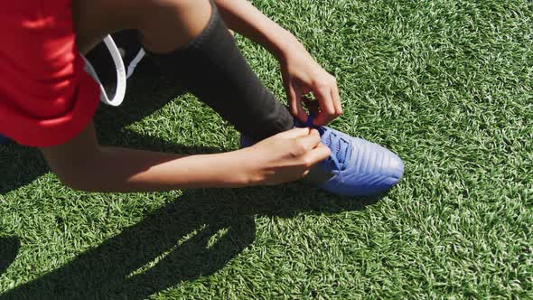 African American soccer kid lacing up his shoe