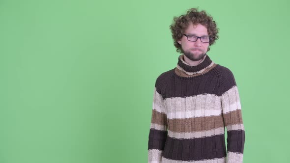 Stressed Young Bearded Man Touching Something and Giving Thumbs Down