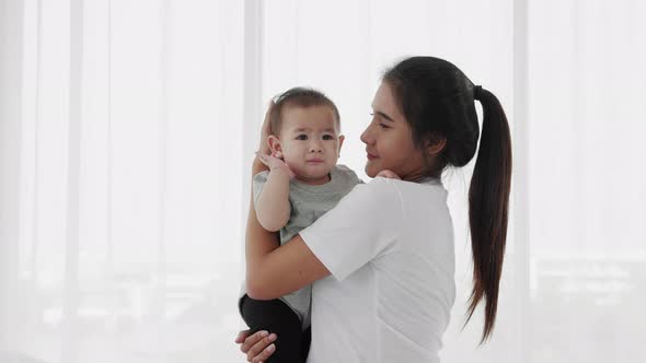 Single mom take care her new born infant on bed. Happy family concept