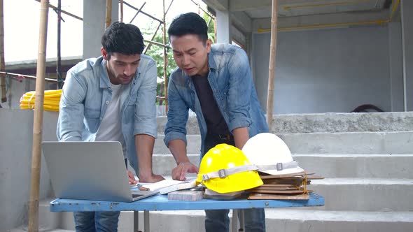 Young Asian engineers and caucasian engineer colleagues at site inspector and discuss together