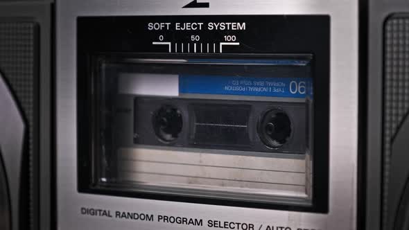 Audio Cassette Tape Rotates in Deck of an Old Tape Recorder