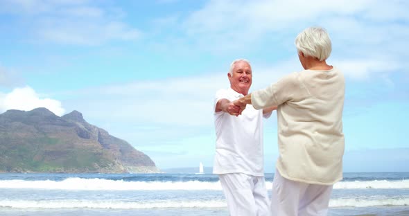 Happy senior couple dancing on the beach