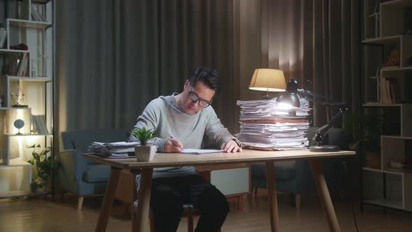 Asian Man Working With Documents At The Home