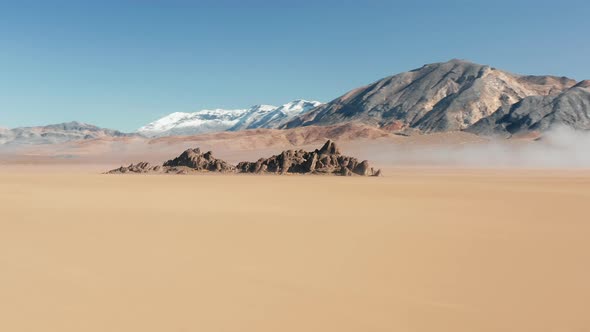 Fast Flight Around Rocks on Flat Surface of Ancient Dry Lake Bed  Aerial