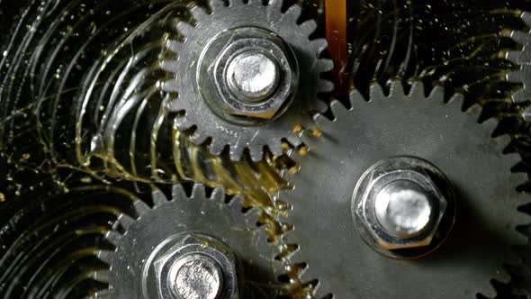 Super Slow Motion Detail Shot of Gear Mechanism and Oil on Dark Background at 1000 Fps