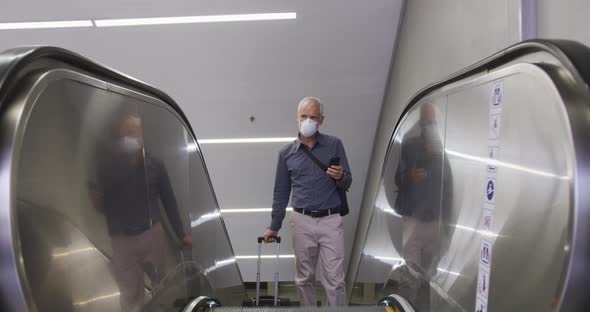 Caucasian man out and about in a metro station wearing on a face mask against coronavirus