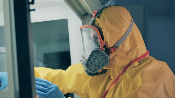 Expert in a Hazmat Suit Is Analyzing Biological Substance