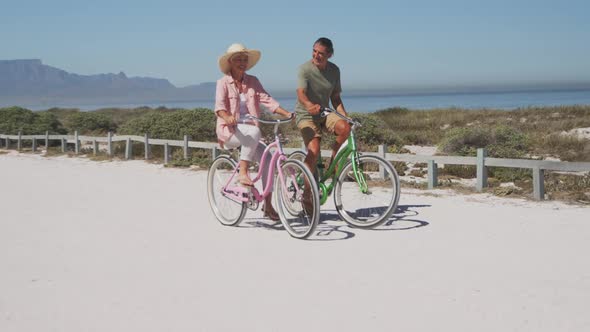 Senior Caucasian couple riding bikes on the beach