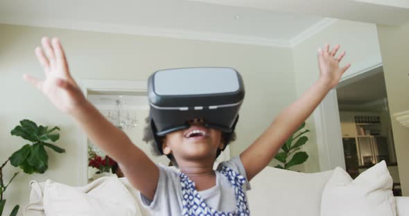 Smiling african american girl playing with vr headset in living room