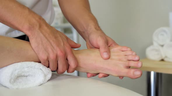 Physiotherapist giving foot massage to a female patient