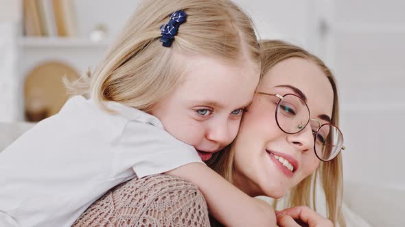 Family Home Portrait Little Daughter Blonde Cute Child Hugs Mom Young Woman with Glasses Around Neck