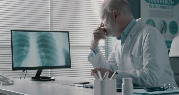 Professional doctor checking medical records in his office