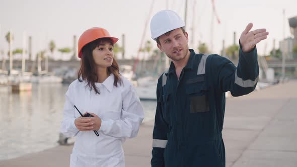 Port Worker Instructing New Female Employee in Marina