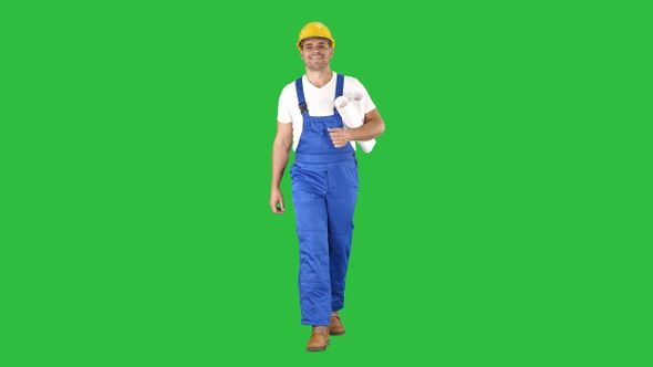 Construction worker walking with blue prints and smiling