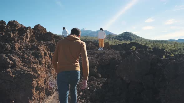 A Group of Tourists Walk Through the Mountains of Solidified Lava in the Teide Volcano National Park