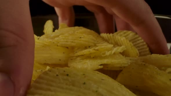 Crop Person Taking Chips From Bowl