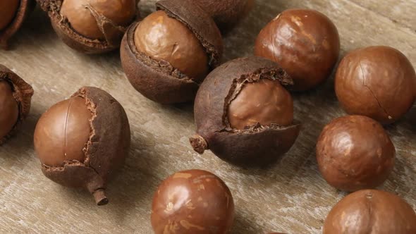 Whole macadamia and peeled nuts in a row close up