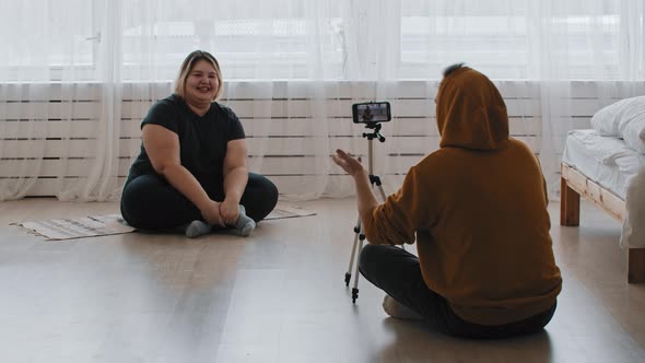 Cute Confident Overweight Woman Feminist and Her Supportive Friend Sitting on the Floor and