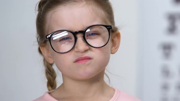 Upset Small Female Kid Taking Off Eyeglasses, Childhood Insecurities, Myopia