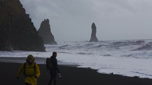 Photographers On Black Sand Beach Watching Rough Sea