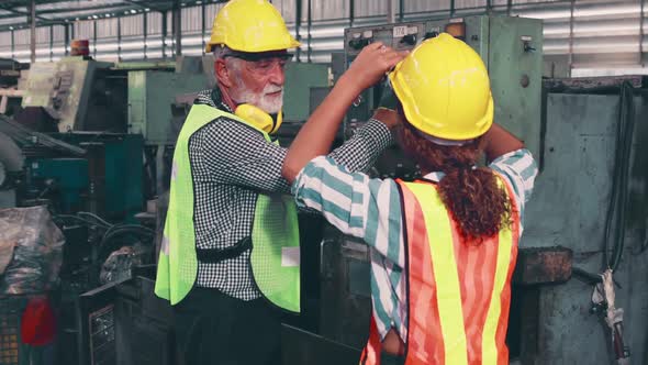 Group of Factory Workers Using Machine Equipment in Factory Workshop