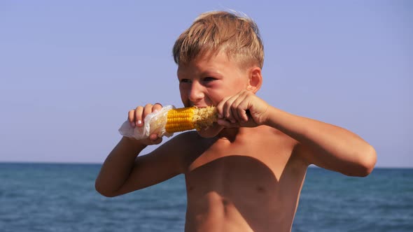 Child Eats Corn on the Seashore