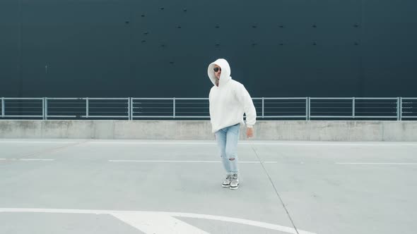 Fashionable Dancer Man in Sportswear and with Glasses Is Performing Outdoor Street Dancing Motion