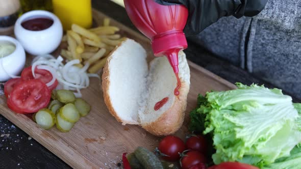 Making Hotdog  Woman Pouring Ketchup Into Bun