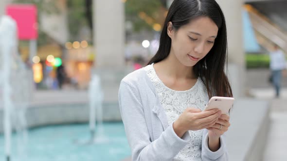 Woman looking at the mobile phone in Hong Kong city