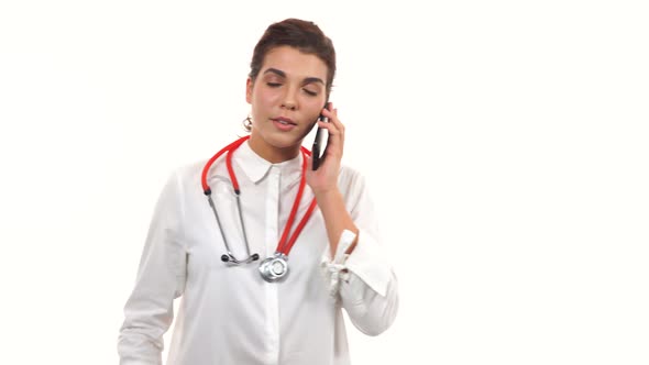 Portrait of a Young Doctor Talking on the Mobile Phone and Walking