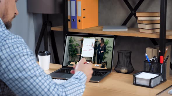 Businessman at Home Office Listen Online Video Call Laptop Writes in Notebook