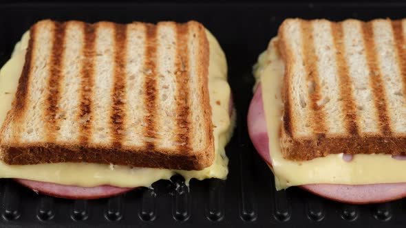 hot sandwich with cheese and ham on grill. grilled cheese sandwich close up