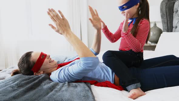 Mother playing clapping game with daughter on bed 4k