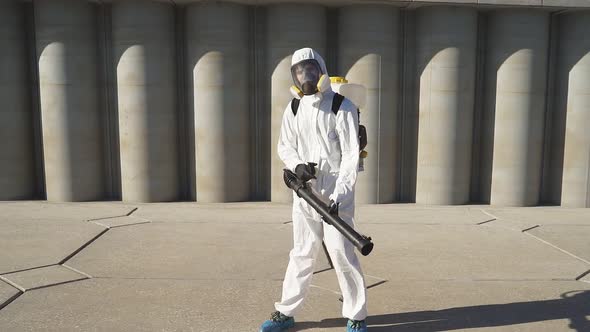 Cleaner with Pressurized Sprayer in Hands Going To Disinfect Public Places.